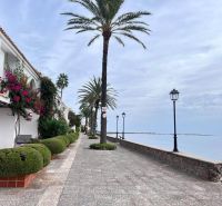 Tengerparti sétány La Manga del Mar Menorban, Spanyolország, pálmafákkal és lámpákkal szegélyezve.