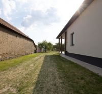 Kilátás egy családi ház udvarára Zemplínska Širokában gyepes területtel.