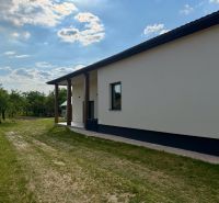 Egy családi ház külseje Zemplínska Širokában, gyep és fák veszik körül.