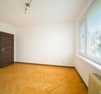 Szoba egy háromszobás lakásban fa dekorációjú padlóval és nagy ablakokkal.