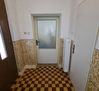 Sakktáblaszerű burkolat egy családi ház belső terében fehér falakkal.