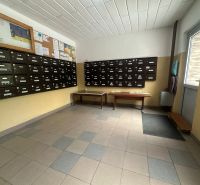 A bejárat belső tere postaládákkal és faliújságokkal a kétszobás lakás területén.