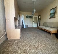 Nappali egy kétszobás lakásban szőnyeggel és fa bútorokkal.