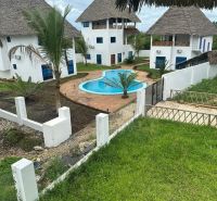 Családi házak Zanzibáron medencével, pálmafákkal és gyepesítéssel trópusi hangulatot teremtenek.