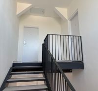 Fémkorláttal ellátott lépcső egy kétszobás lakásban, minimalista stílusban.