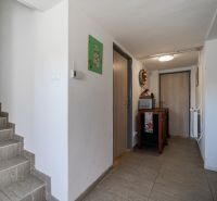 Családi ház előszobája fa dekorációjú padlóval és lépcsővel.