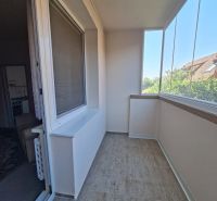 Üvegezett loggia csempével a háromszobás lakásban, mellette lakóterek.