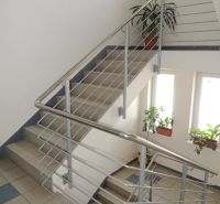 Lépcső az irodában rozsdamentes korláttal, virágokkal és nagy ablakokkal.