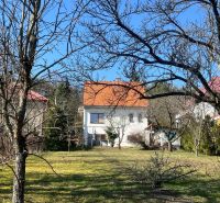 Családi ház Podhájban, Kráľovában, fákkal és gyepes területtel körülvéve, narancssárga tetővel.