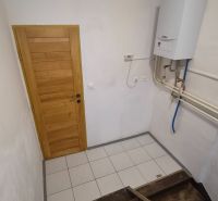 Lépcső fa lépcsőfokokkal és gázkazánnal egy kétszobás lakásban.