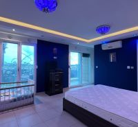 Hálószoba nagy ággyal, gyerekággyal és légkondicionálóval egy üdülő apartmanban.