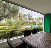 Nyaraló apartman terasszal, kilátással a medencére és a kertre.