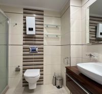 Fürdőszoba a nyaraló apartmanban WC-vel, zuhanyzóval és mosdóval.