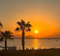 Naplemente pálmafákkal és tengerrel La Manga del Mar Menorban, Spanyolország.