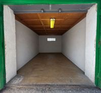 Nyitott garázs fa mennyezettel és betonpadlóval.
