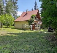 Házikó Ružinánál, fákkal és zölddel körülvéve, autóval a felhajtón.