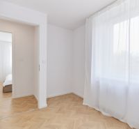 Szoba fehér függönyökkel és fa dekorációjú padlóval egy 4 szobás lakásban.