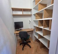 Dolgozósarok fa mintás padlóval és polcokkal egy kétszobás lakásban.