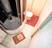 Kényelmes fürdőszoba egy kétszobás lakásban káddal, mosdóval és WC-vel.