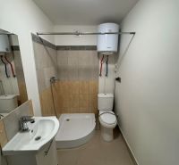 Fürdőszoba egy kétszobás lakásban káddal, mosdóval és WC-vel, világos csempe a falakon.