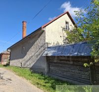 Családi ház Šumiacban bádogtetővel, amely a zöld természettel és az úttal szomszédos.