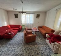 Nappali egy családi házban piros és narancssárga kanapékkal és szőnyeggel.