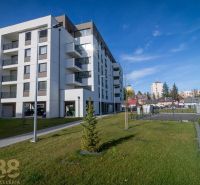 Egy lakóház Poprádon zöld gyepes területtel és a háttérben szomszédos épületekkel.