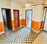 Folyosó egy családi házban, csempével és fa dekorációval a falakon.