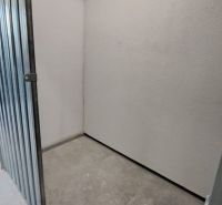Kis raktárhelyiség fém ajtókkal és betonpadlóval egy kétszobás lakásban.