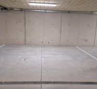 Földalatti garázs betonpadlóval és világítással.
