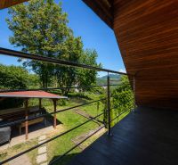A ház erkélye kilátással a zöldre és a pavilonra a Klučina utcában, Považská Bystrica.