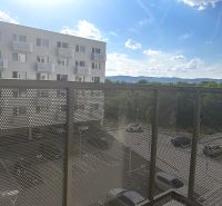 Erkély egy egyszobás lakásban, kilátással a parkolóra és a környező hegyekre.