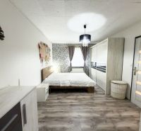 Hálószoba családi házban, fa dekorációjú padlóval és ízléses berendezéssel.
