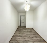Keskeny folyosó egy családi házban, fa dekorációjú padlóval és fehér mennyezettel.
