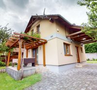 A mocsai házikónak van egy terasza fa pergolával és zölddel a Mocsai utcán.