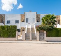 Nyaraló apartman Cala Muradában, Mallorcán, modern homlokzattal és zöld sövénnyel.