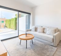 Nyaraló apartman kényelmes kanapéval, asztallal és nagy ablakkal.