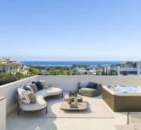 Terasz az Estepona-i üdülő apartmanban modern bútorokkal, pezsgőfürdővel és tengerre néző kilátással.
