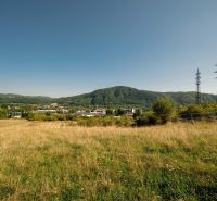 Rét és elektromos oszlopok a Partizánska úton, Besztercebánya. Telkek - lakóövezet.