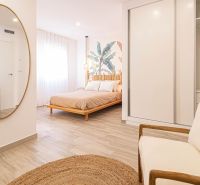 Nyaraló apartman belső tere ággyal, tükörrel és fa dekorációjú padlóval.