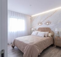 Hálószoba egy üdülő apartmanban ággyal, szövetfüggönyökkel és fa dekorációjú padlóval.