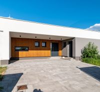 Családi ház Kassa-környéken minimalista homlokzattal, fa elemekkel és szilárd burkolattal.