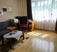 Nappali egy négy szobás lakásban fa dekorációjú padlóval és dolgozósarokkal.
