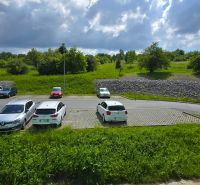 Parkoló autókkal a Ďumbierska utcán, Eperjesen, zölddel és éggel körülvéve.