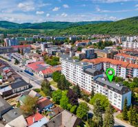 Légi felvétel Púchovról és a Mudroňova utcáról lakóépületeket és zöldterületeket mutat.