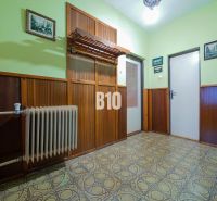 Családi ház előszobája fa burkolattal és vintage radiátorral.