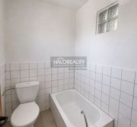 Fürdőszoba családi házban káddal, WC-vel és fehér csempékkel.