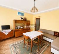 Nappali egy családi házban szőnyeggel és bútorokkal, fa dekoros padlóval.