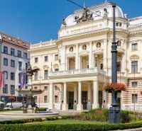 A Szlovák Nemzeti Színház történelmi épülete a pozsonyi Hviezdoslav téren zöld növényzettel.