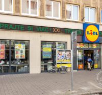 Lidl a Grössling utcán Pozsonyban - Óváros, járókelőkkel és kerékpárral.